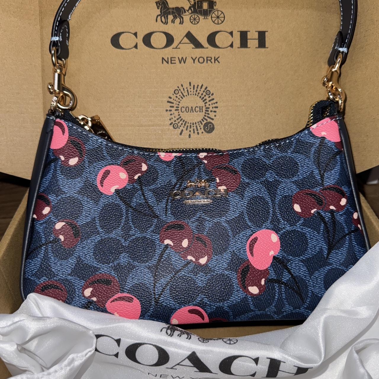 Navy blue Coach shoulder bag with pink cherries