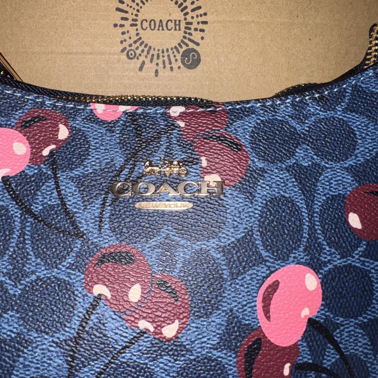 Navy blue Coach shoulder bag with pink cherries