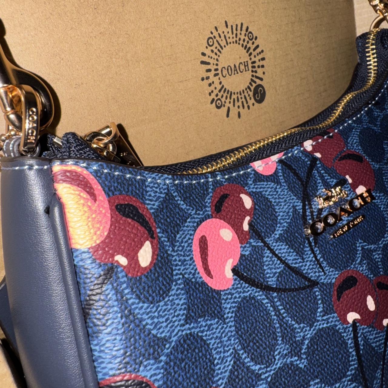 Navy blue Coach shoulder bag with pink cherries