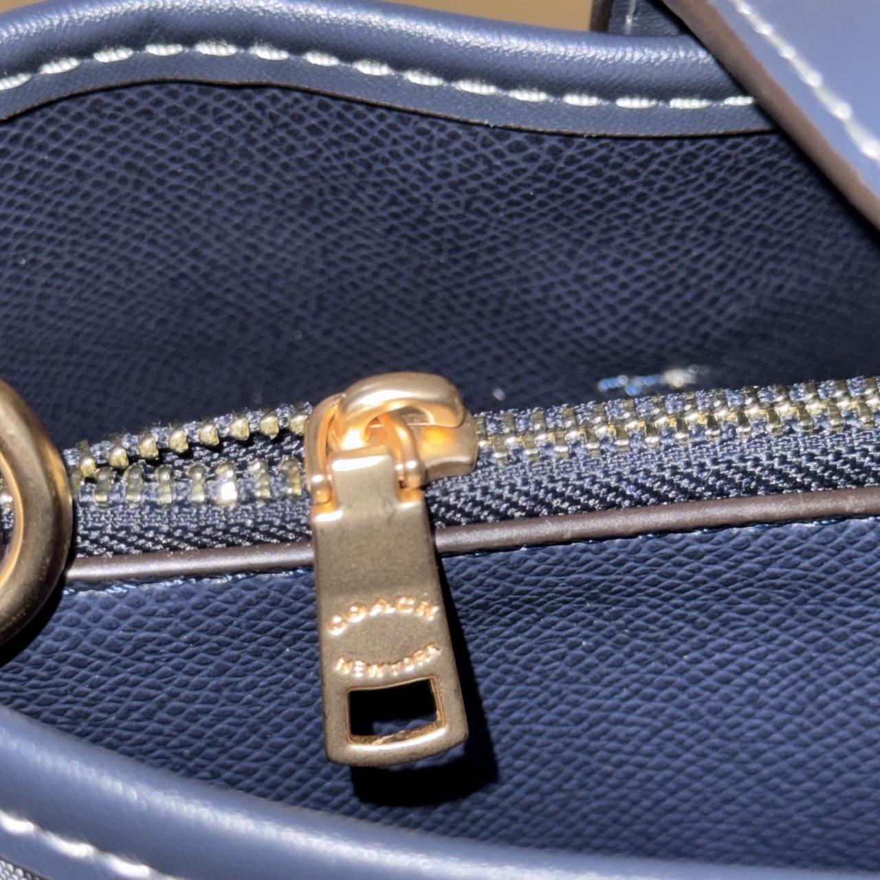 Navy blue Coach shoulder bag with pink cherries